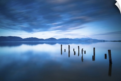 Wooden Pier Or Jetty Remains On A Blue Lake, Sunset And Sky Reflection