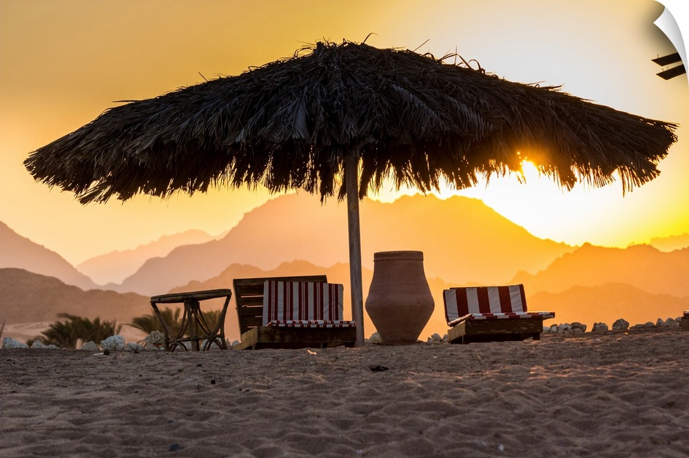 Egypt, Sinai, Sharm el Sheikh, Red sea, Nabq Bay, beach beds at sunset with Sinais mountains behind.