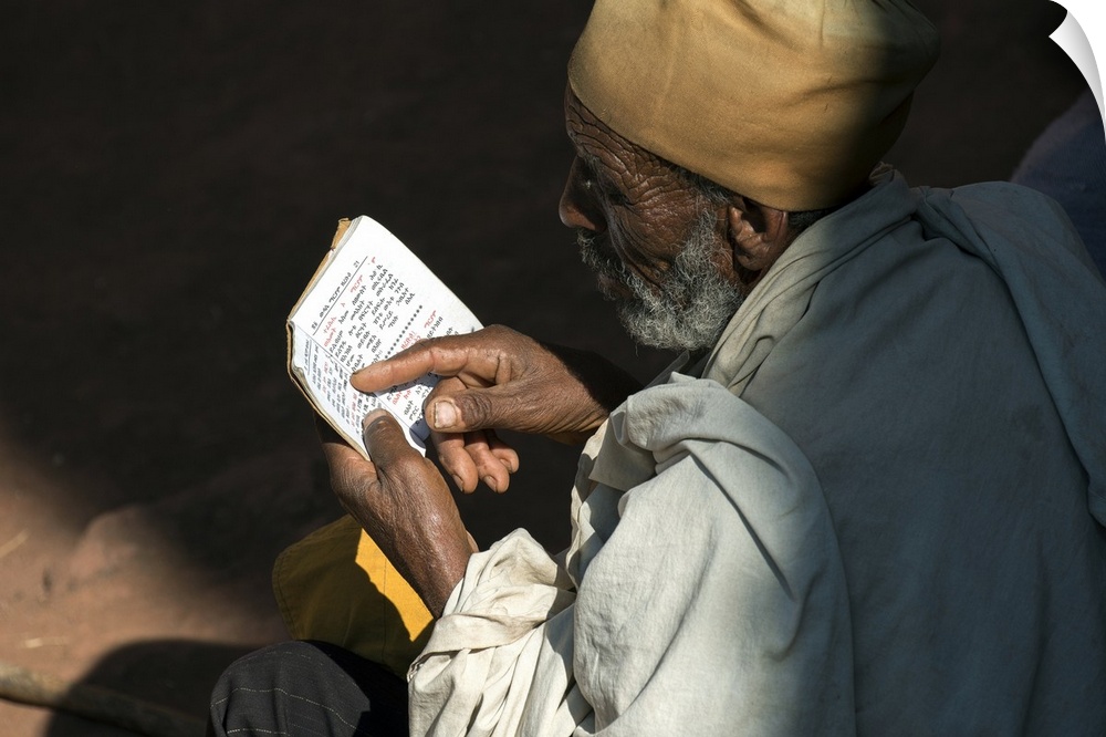 Ethiopia, Amhara, Lalibela, Monk reading Bible at Biete Abba Libanos.