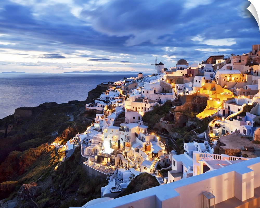 Greece, Aegean islands, Cyclades, Santorini island, Greek Islands, Oia village illuminated at dusk.