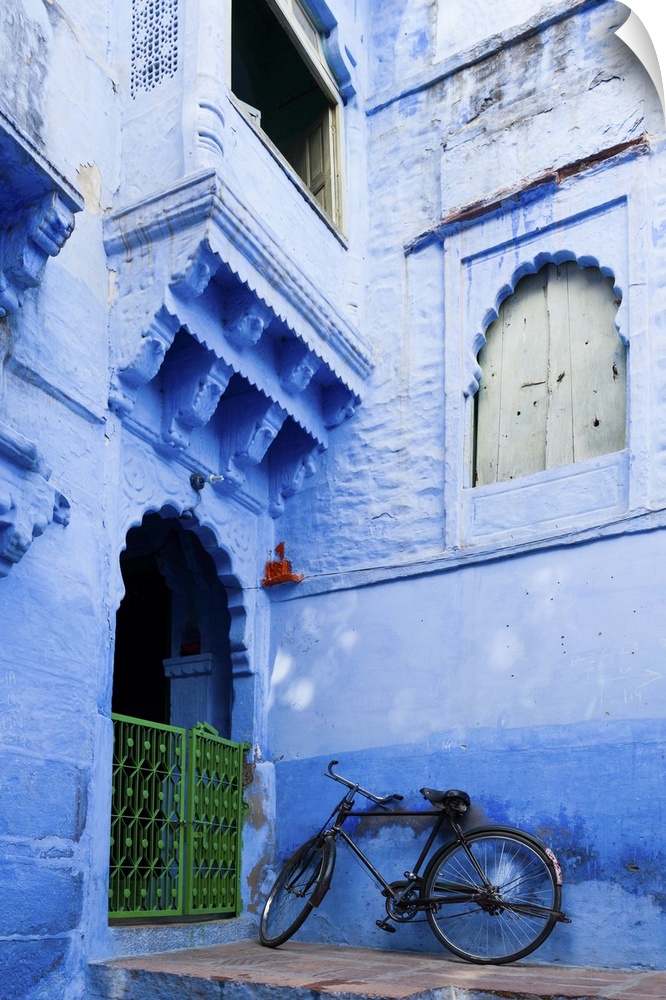India, Rajasthan, Jodhpur, Bike resting against a wall of a blue house.