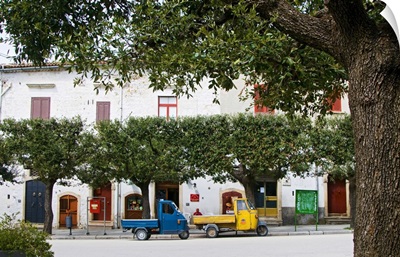 Italy, Apulia, Bovino, Two motorcars called Ape parked under the trees