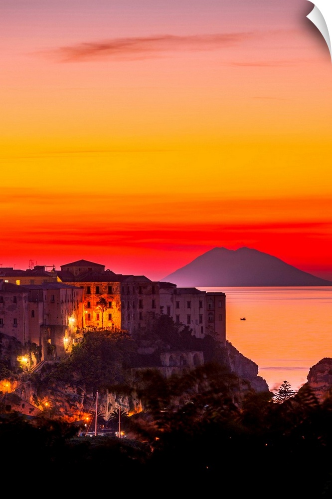 Italy, Calabria, Mediterranean area, Vibo Valentia district, Tropea, Town at sunset with Stromboli Island in the background.