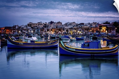 Malta, Marsaxlokk, Luzzu, traditional fishing boats and Marsaxlokk harbor at dusk