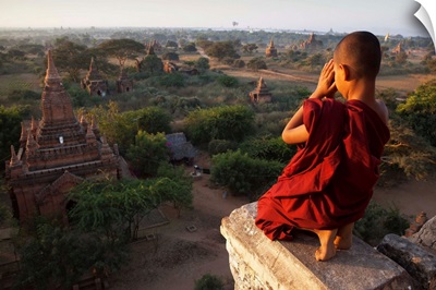 Myanmar, Bagan, A novice Buddhist monk prays on a temple at sunrise