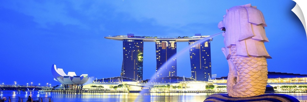 Singapore, Singapore City, Merlion fountain at night with the Marina Bay Sands in the background.