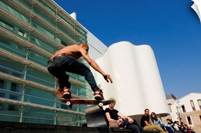Spain, Barcelona, skateboarder performing jump in front of a museum