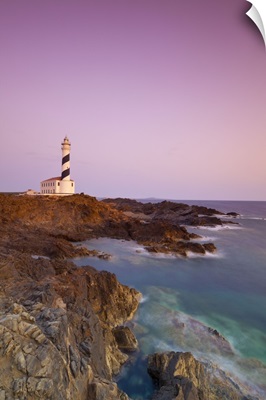 Spain, Minorca, Far de Favaritx lighthouse and rugged coastline at dawn