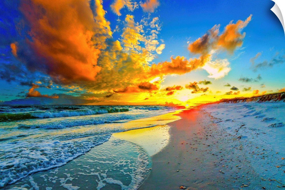 A dark and beautiful blue sky at sunset. An orange sunset expands outward from a yellow sun over a beach and seascape sunset.