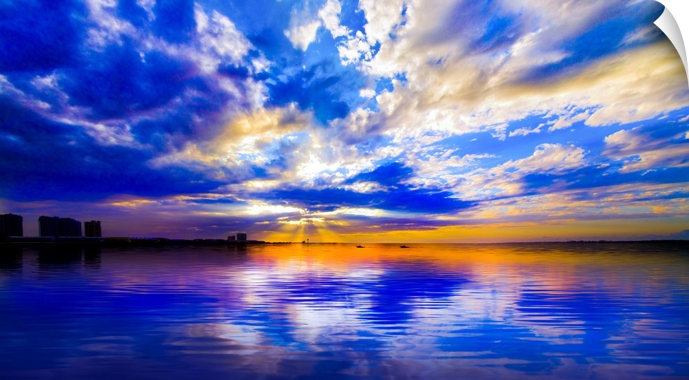 The sunset reflected in this blue and white seascape during sunset.
