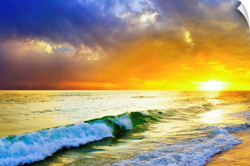 Waves breaking from an emerald sea beneath an orange and blue ocean sunset with green sea surf.