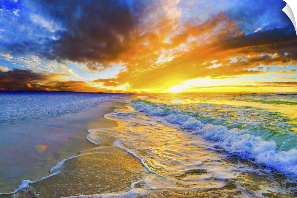 A bright orange and blue sunset over a beautiful beach. Green and gold ocean waves roll across the sea shore.