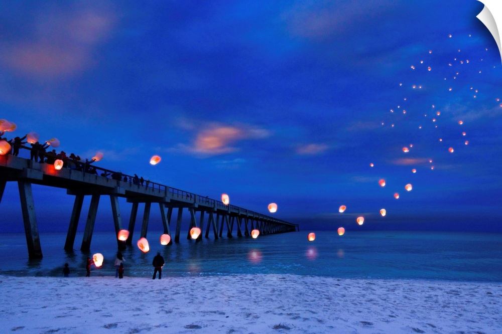 Residents are launching paper lanterns off navarre pier in memory of fallen soldiers on veterans day. Landscape taken on N...