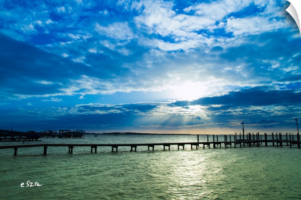 A lonely pier on a shimmering sea in Pensacola, Florida.