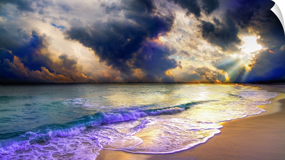 A panoramic beach sunset with blue clouds and ocean waves.