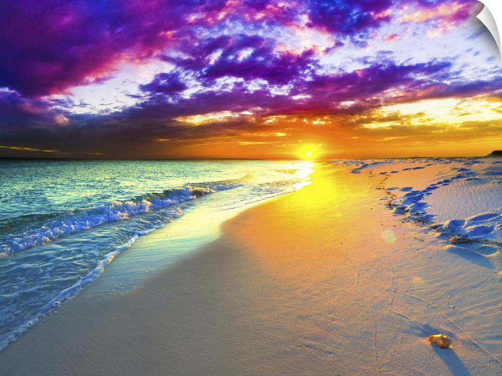 A beautiful purple and blue sunset over a sandy beach shoreline. The ocean takes up a small part of the beautiful picture.