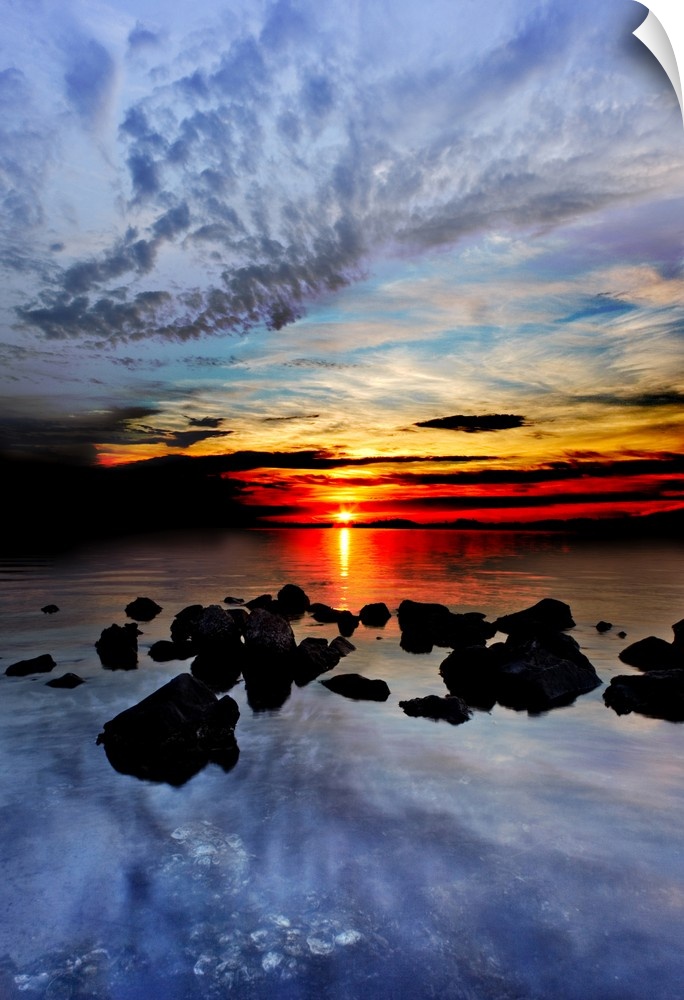 Blue clouds reflected in the sea in the red sunset landscape.