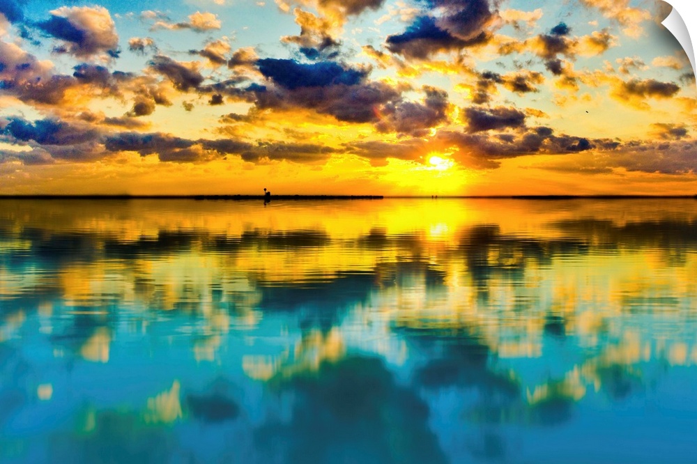 A blue and yellow sunset lake reflection of a skyscape.