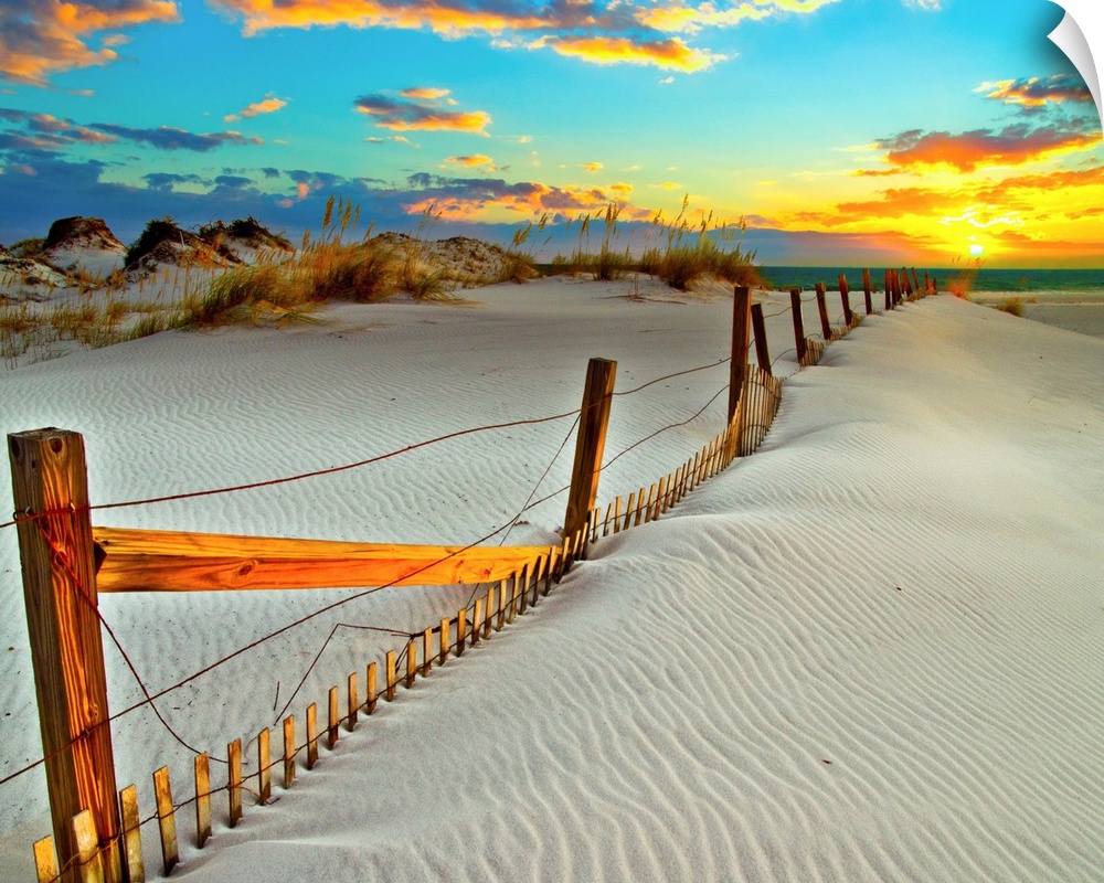 A white sand beach sunset with a crooked wooden fence.