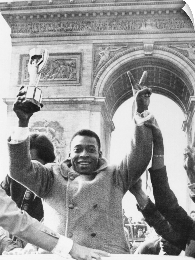 Brazilian soccer star Pele waves the Jules Rimet Cup from an open car on Paris' Champs Elysees. March 30, 1971. In the bac...