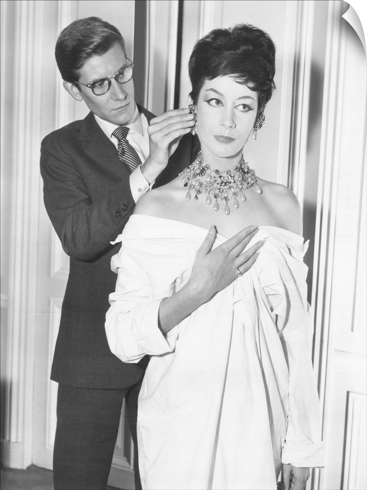 French fashion designer Yves Saint Laurent putting earing on model. Jan. 18, 1962.
