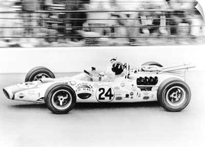 Graham Hill, waves as his car streaks toward the finish line to win the Indianapolis 500