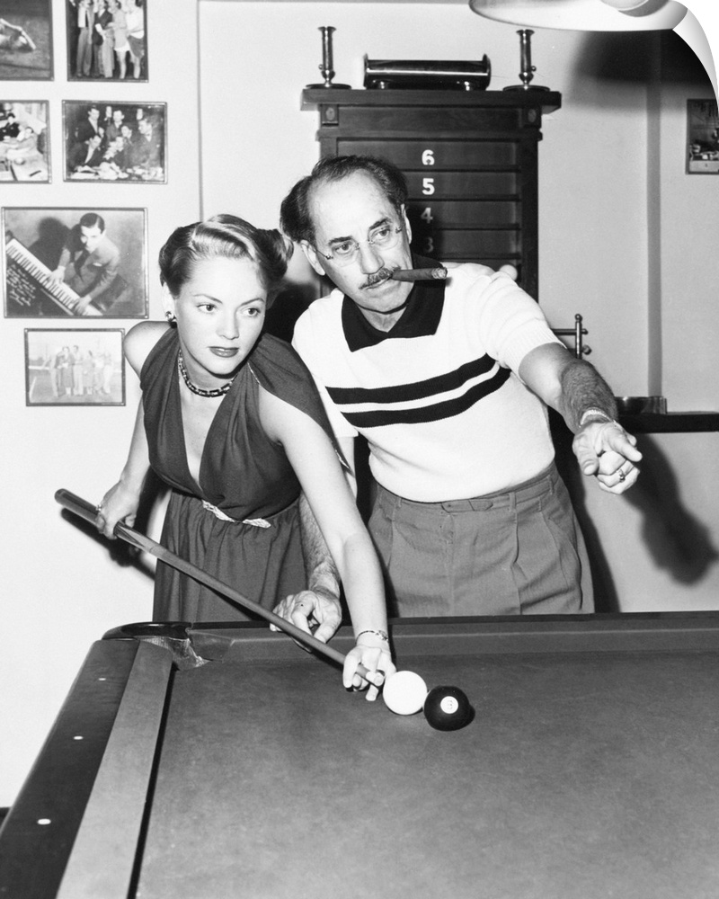 Groucho Marx at home playing billiards with his young wife, Actress Kay Maris in 1949. Her first husband was Actor Leo Gor...