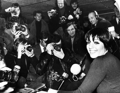 Liza Minnelli is surrounded by photographers during an airport news conference