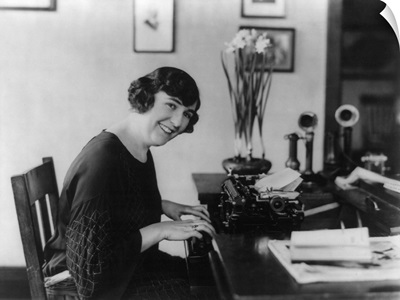 Smiling woman office worker seated at typewriter, in 1923
