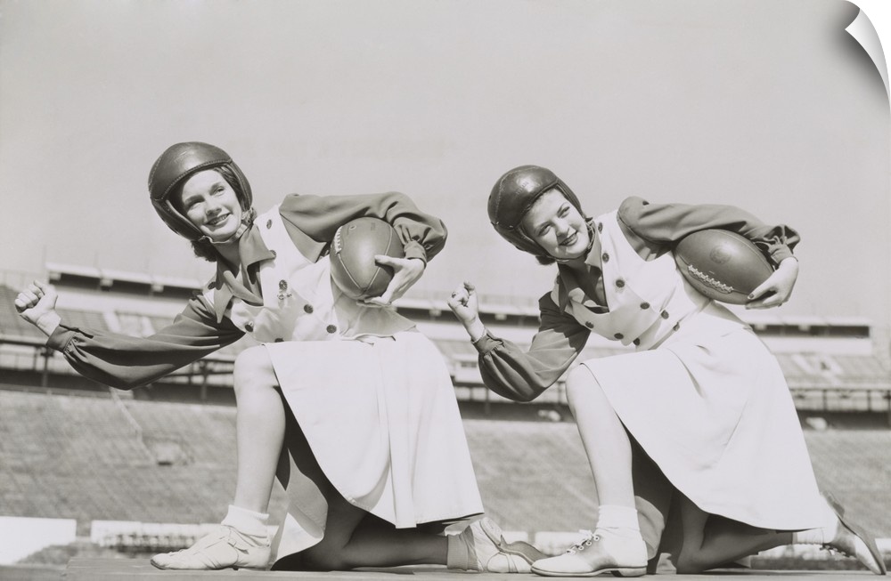 Two cheerleaders from Tulane University, Oct. 5, 1942. They are wearing football helmets and holding footballs.