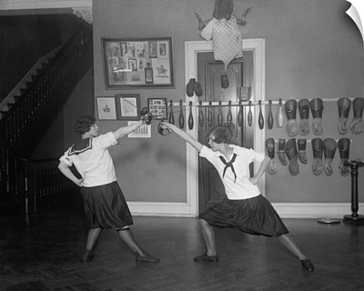 Young women in bloomers and middy shirts fencing