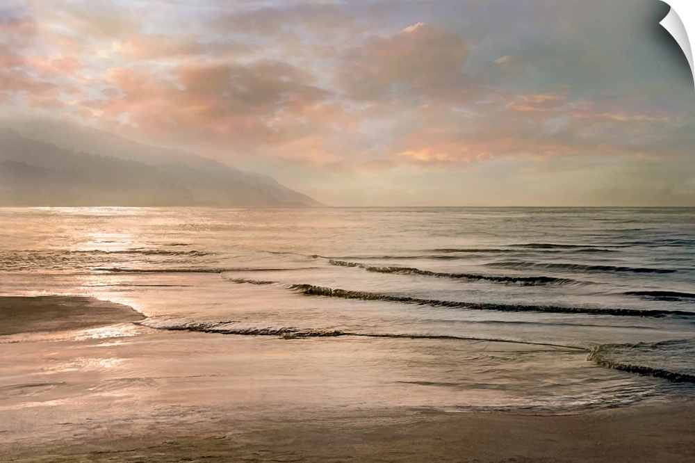 A photograph of small waves coming to shore with mountains in the background and a pink sunset.