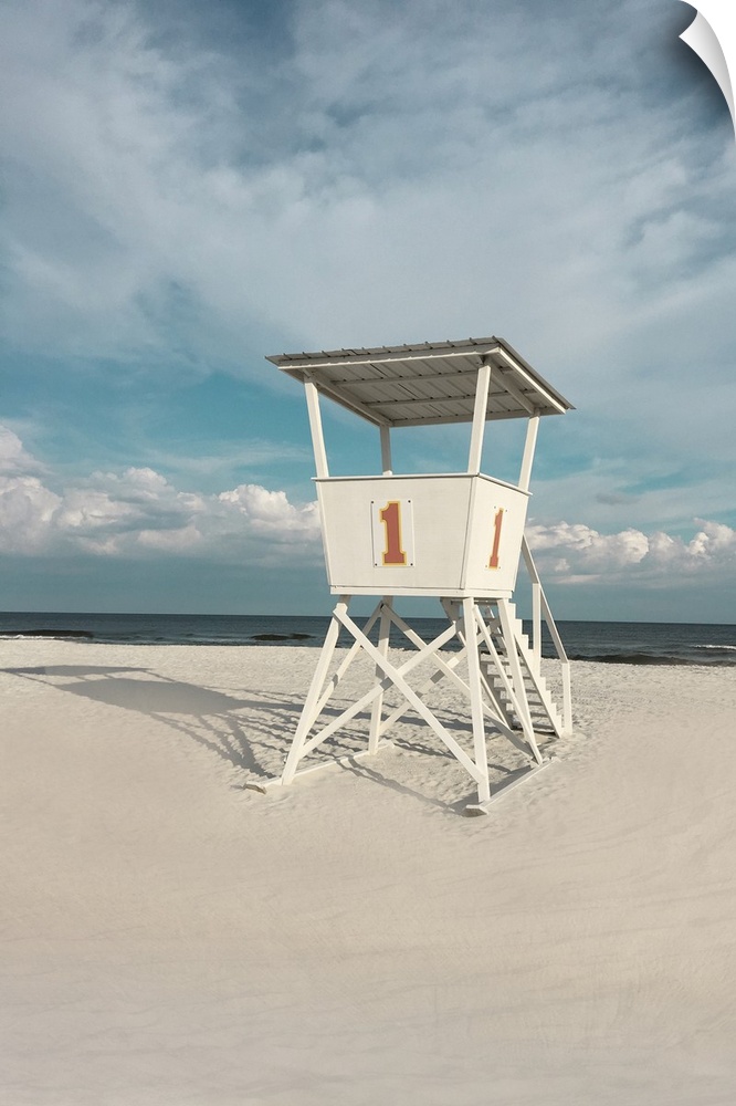 A photo of a lifeguard tower on a cloudy day with an unoccupied beach in the background.