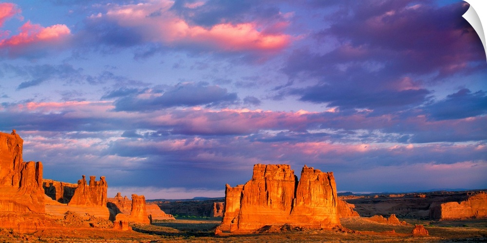 Tall rock formations illuminated at sunset in Arches National Park, Utah.