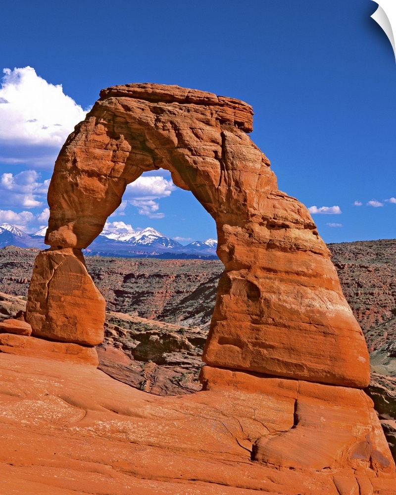 Bright red natural arch on a cliff in Arches National Park, Utah.