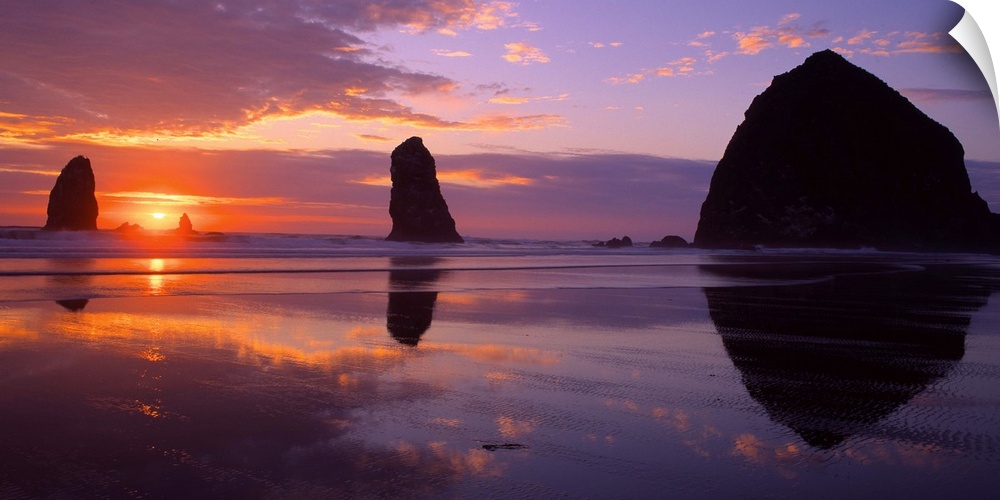 Sea stacks on the beach silhouetted at sunset, Cannon Beach, Oregon.