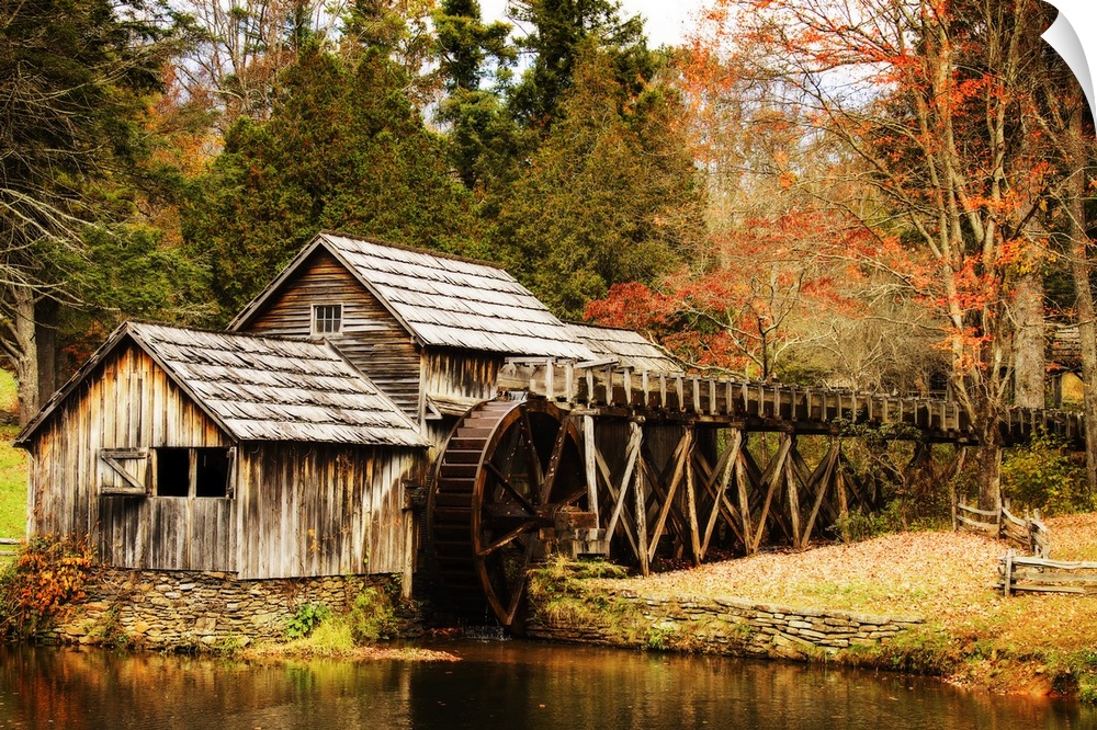 An old wooden watermill in a forest in autumn.