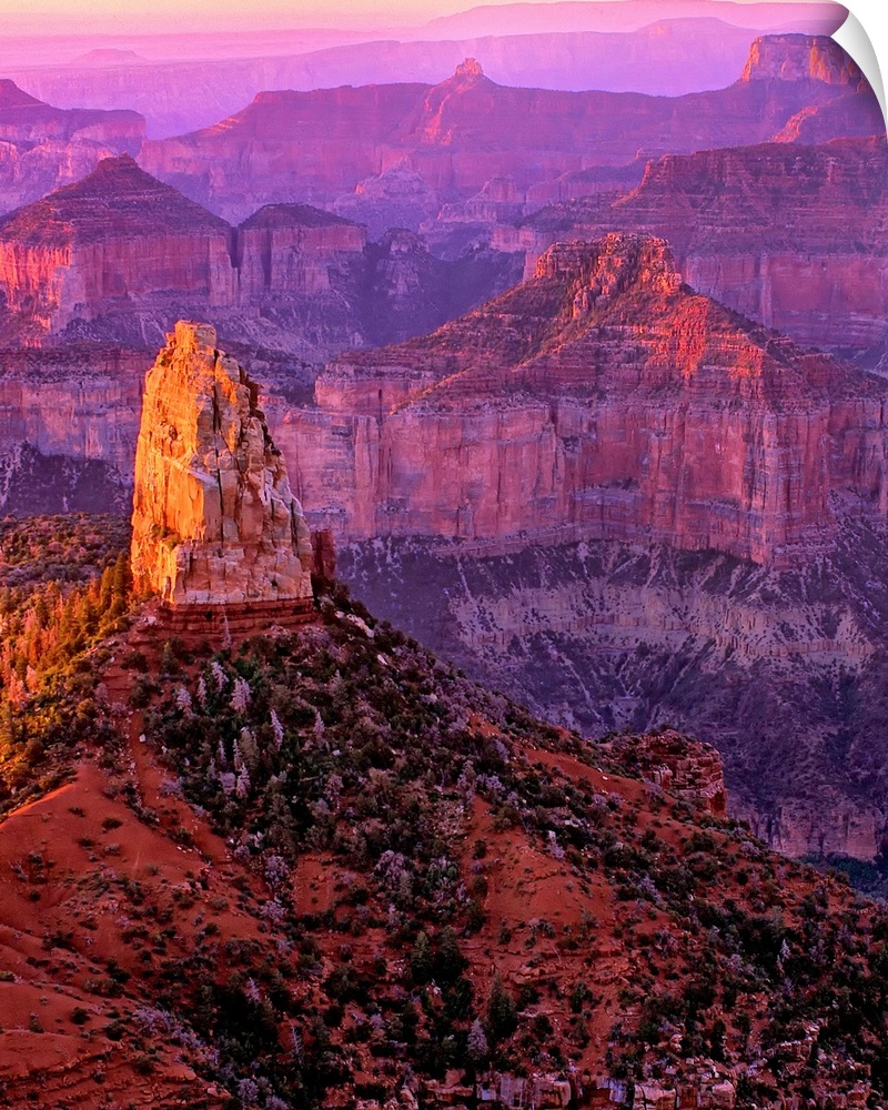 Tall rock formations in purple and red light in Arizona.