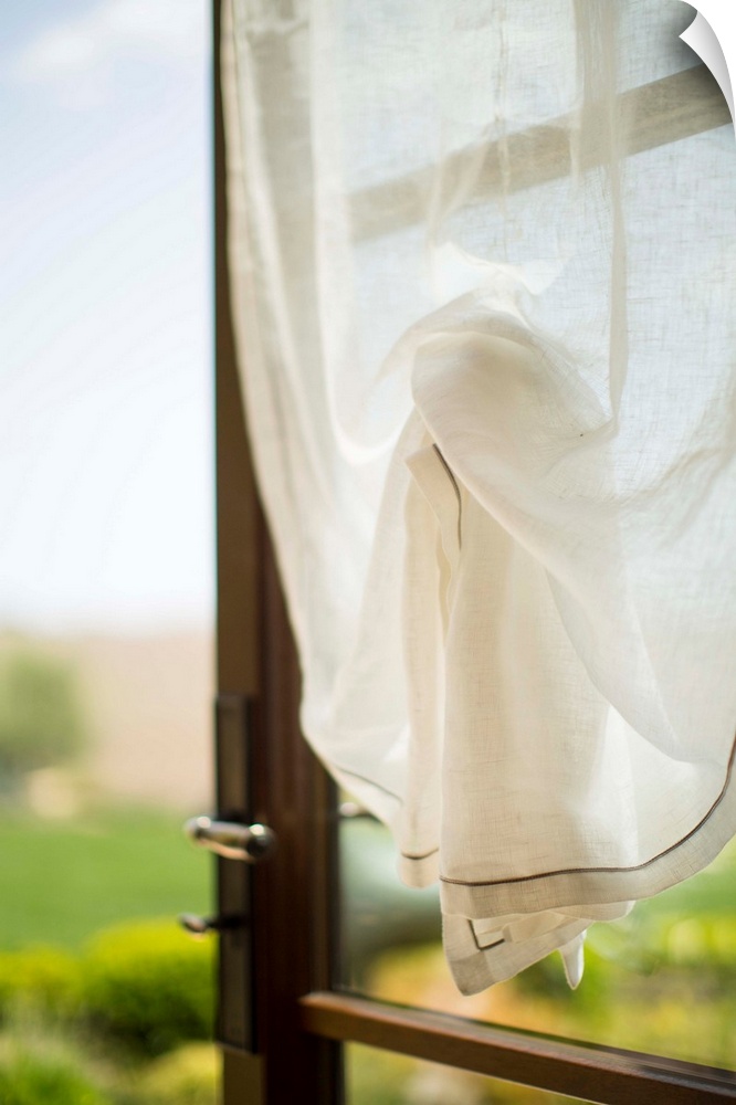 An open window with a white curtain.