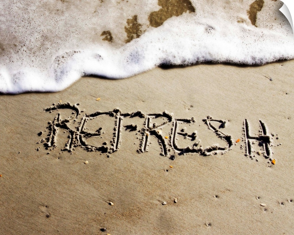 The word "Refresh" drawn in the sand near the ocean water.