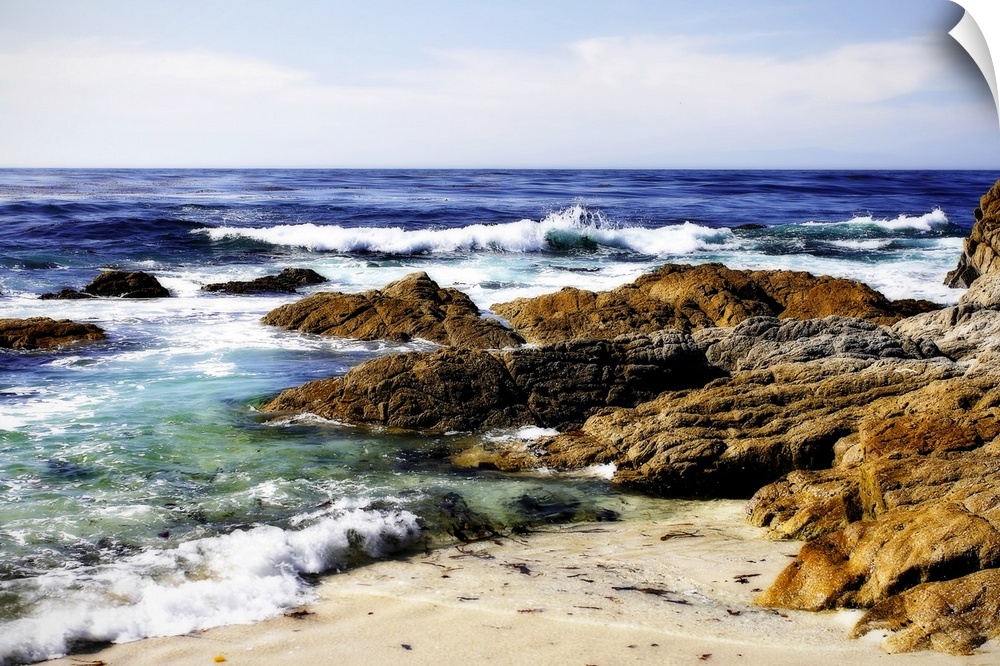 Photograph of rocky shoreline with waves crashing in.