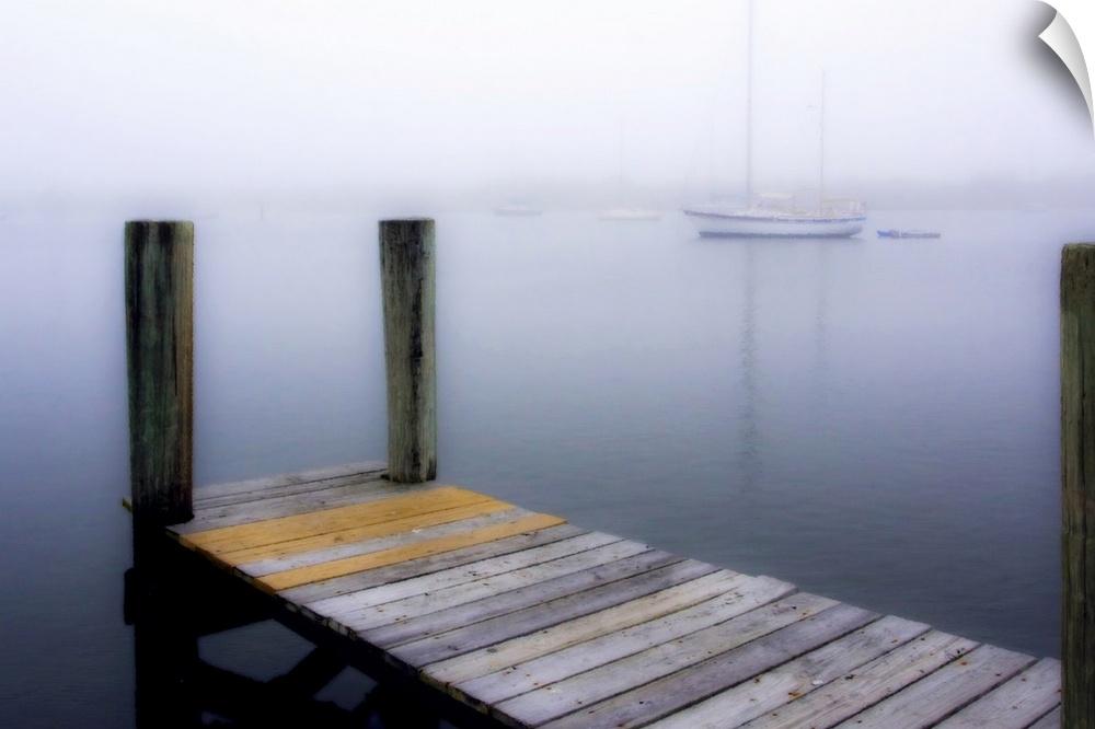 Giant, horizontal wall picture of a wooden dock leading into calm water, several boats can be seen in the foggy background.