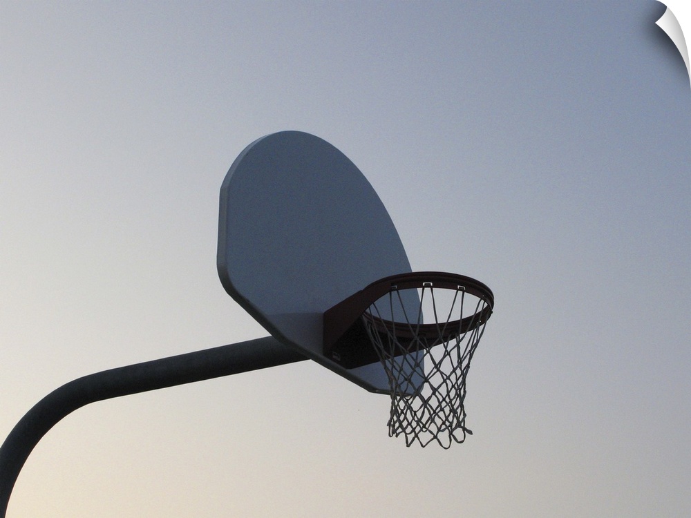A basketball backboard hoop and net. Clear blue sky
