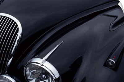 a black jaguar sports car hood showing a grill and headlight