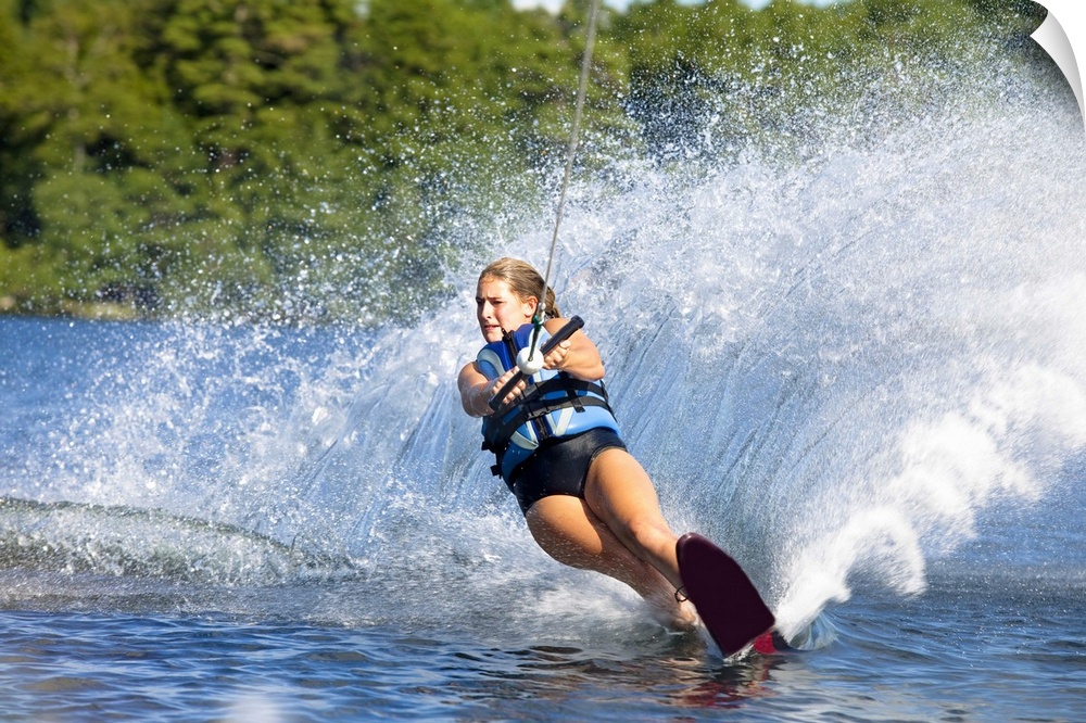 A female water skier rips a turn causing a huge water spray while skiing on Cobbosseecontee Lake near Monmouth, Maine.