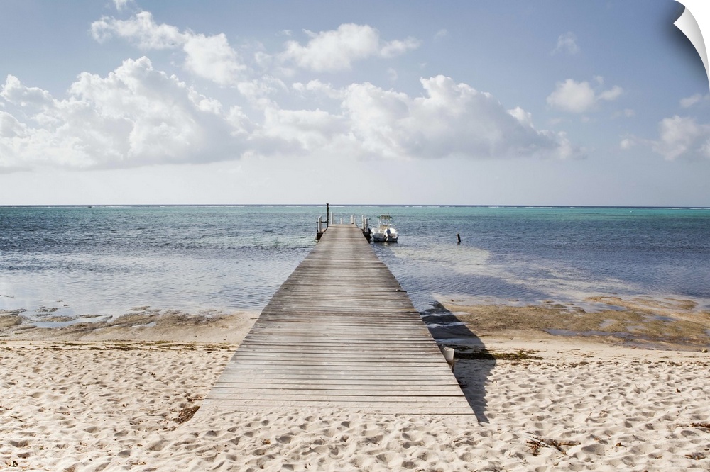 A long dock with a boat at the end stretches out into South Hole Sound on Little Cayman