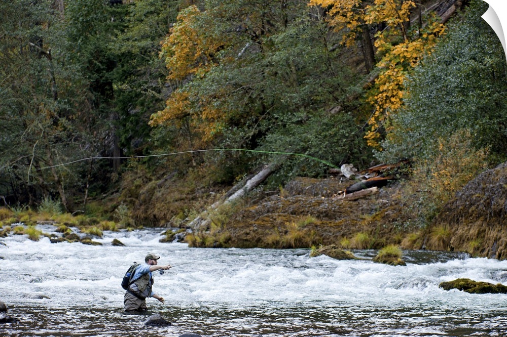 A fisherman tries his luck in the rapids of a quick moving river.