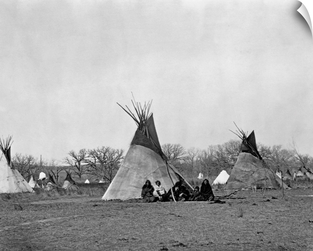 A Comanche Indian family sits outside their teepee in the Iron Mountain's Camp, 1873.