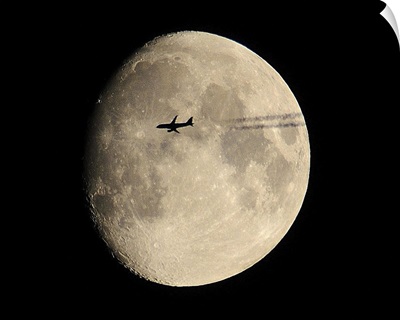 A plane in front of the moon