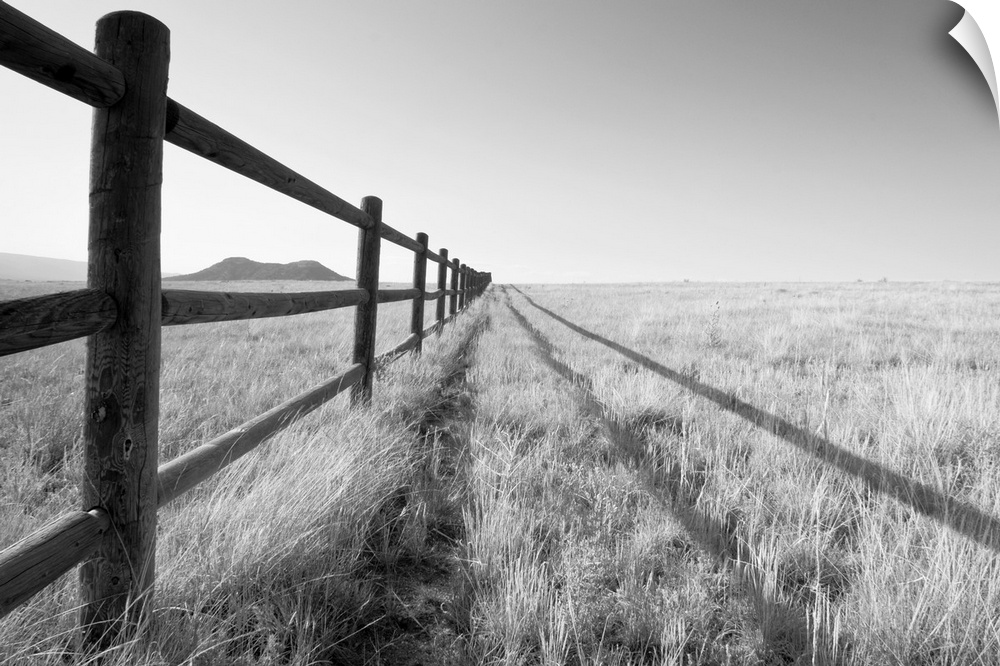 A split rail fence vanishing into the horizon and framing a mountain in the foreground. Aspen, Colorado